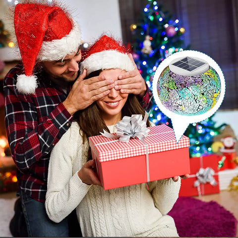Couple with Santa hats exchanging gifts, highlighting Color Changing Mosaic Solar Glass Globe Light for Garden Patio Yard