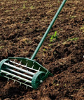 Rolling Lawn Aerator 18 Inch Rotary Push Tine Spike Soil Aerator for garden yard with 3 piece long steel handle in use