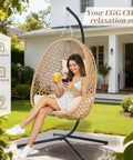 Woman sitting in Hanging Egg Chair With Cushions And Stand For Patio Garden Or Balcony Chill Outdoor Swing Chair Cozy Rattan Lounge Seat For Indoor Or Outdoor Use 350 Lbs Capacity Yellow