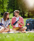 Couple enjoying picnic with Soft Lightweight Leakproof Backpack Cooler For 35 Cans, Insulated Bag, on grass