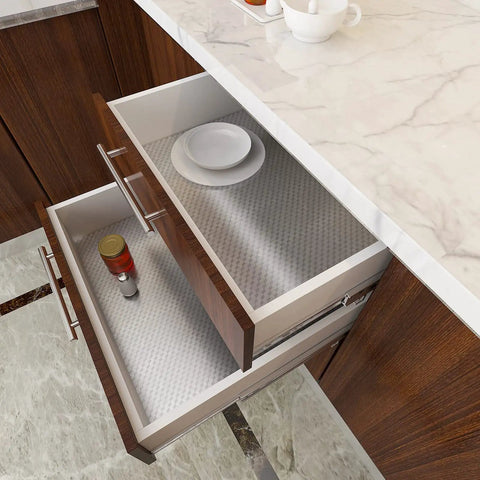 Open kitchen drawers lined with silver stainless steel contact paper, showing peel and stick aluminum foil application