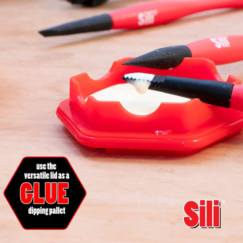 Glue Pod With Three Micro Glue Brushes And Sealable Lid Set on a table, with flat tapered tip brush in use