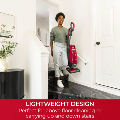 Woman using Hassle Free Bagged Upright Vacuum With No Touch Auto Dump and Smooth Lift Up Pod For Stairs on stairs for easy cleaning.