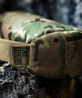 Close-up of camo Pre-Filled Shooting Rest Bag For Front And Rear Gun Support Durable 500D Cordura Nylon on rocky surface.
