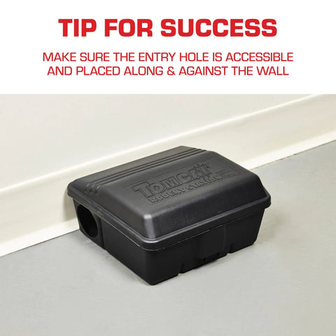 Rodent Station Trap Box With Four Bait Securing Rods And Security Key placed against wall for indoor outdoor use.