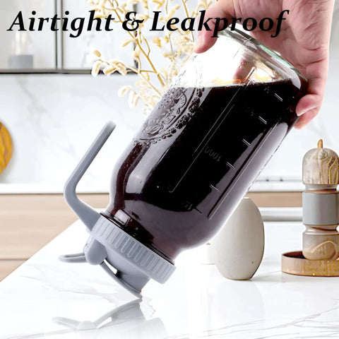 32 Oz Mason Jar Cold Brew Pitcher With Strainer And Wide Mouth Glass Spout Lids For Fridge Iced Coffee Tea Lemonade Sun Tea 1 Quart Brew Maker Dishwasher Safe No Mess shown tilted with coffee inside