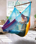 Person relaxing in Upgraded Caribbean Hammock Chair With Detachable Steel Bar Large XL Rope Hanging Swing Chair For Outdoor And Indoor Use