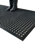 Front view of a black rubber drainage mat with circular holes; anti-slip for outdoor or indoor wet areas.