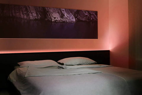 Bedroom with Smart LED Light Strip With Full Color Spectrum And White 1800 Lumens Adaptive Lighting above headboard.