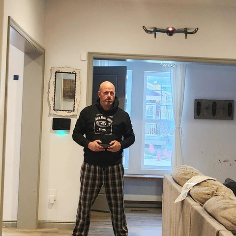 Man indoors flying a 4K Camera Drone For Kids And Adults, Foldable Silent Quadcopter with 120 Degree Wide Lens, 60fps HD Video And Photos