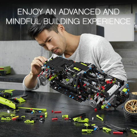 Man assembling Lamborghini Sian FKP 37 1:8 Scale Tech Model Car Kit for Grownups with 3,696 pieces on a table.