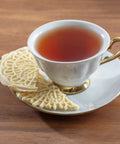 Cute Mini Electric Pizzelle Maker Creates Single 4 Inch Italian Waffle Cookies served with tea in elegant cup.