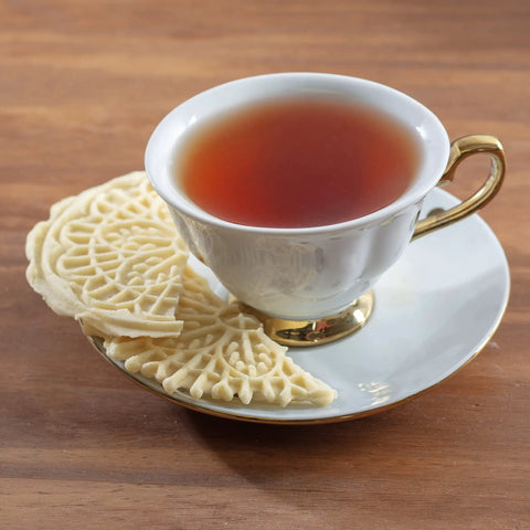 Cute Mini Electric Pizzelle Maker Creates Single 4 Inch Italian Waffle Cookies served with tea in elegant cup.