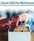 Person opening gift box containing 6 Inch Glass Mosaic Hanging Bird Feeder For Outdoors with colorful confetti mosaic design.
