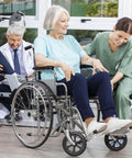 Elderly woman in a wheelchair with a nurse assisting, doctor writing notes on the side, medical setting with large windows.