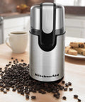 Blade Coffee Grinder With One Touch Control, 4 Ounce Capacity, Onyx Black, on kitchen counter next to coffee beans and cup