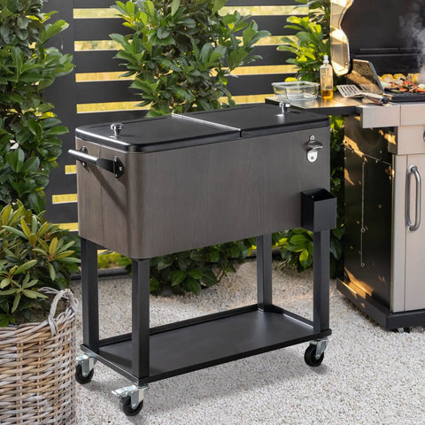 80 Quart Rolling Patio Cooler With Bottle Opener And Cap Catcher in gray on wheels, beside outdoor grill
