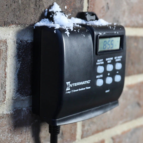 Outdoor Timer With 7 Day Programming And Astronomic Self Adjust mounted on brick wall with snow, weatherproof enclosure