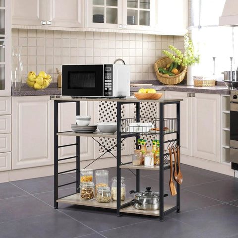 Sturdy Kitchen Bakers Rack With Wire Basket And Six S Shaped Hooks in kitchen, microwave and condiments on top, gray metal frame.