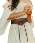 Dope Renaissance Obi Belt With Snatched Medieval Leather Corset Style Game Changing Wide Cinch Strap on a model wearing a dress.