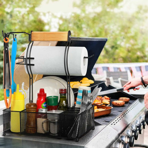 Grill Caddy With Paper Towel Holder And Seven Compartment Organizer For Outdoor BBQs, utensils, condiments on a barbecue grill.