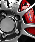 Brake caliper temperature indicator strips on a red brake caliper beside a silver wheel