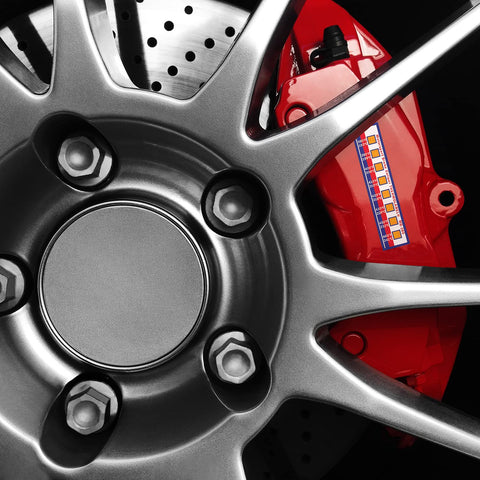 Brake caliper temperature indicator strips on a red brake caliper beside a silver wheel