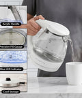 1.5 Liter Glass Electric Kettle With Blue Led Glow Rapid Boil Auto Shutoff in use pouring water into a cup.