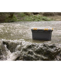 Tough As Nails 12 Gallon Waterproof Storage Tote With Clear Polycarbonate Lid in a stream, showcasing durability and water resistance.