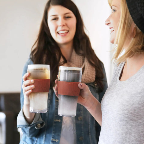 Level Up Your Chill Game With These Freezable Pint Glasses Double Walled Insulated Tumblers That Keep Beer And Iced Coffee Straight Frosty Built To Last Set Of Two Wooden Handles, two women holding cold drinks.