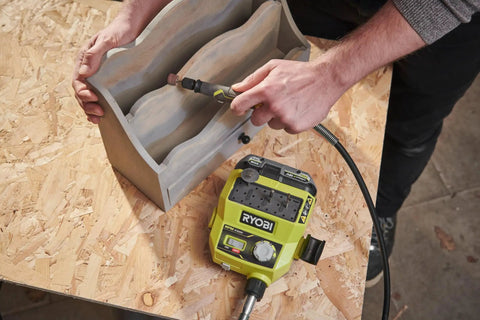 Man using Badass 18 Volt Cordless Mini Rotary Tool With 35 Premium Accessories on carved wooden object.