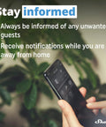 Hand holding phone showing smart home app; "Stay informed" message with notification alerts, green plant in background.