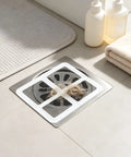 Hair Drain Stickers 100Pcs Disposable Self Adhesive on a shower drain, capturing hair and soap scraps.