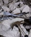 Hammer, masonry chisel and spiral drill bit on concrete rubble