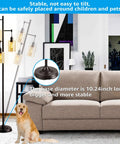 Three-Head Industrial Farmhouse Floor Lamp With Amber Glass Shades beside a sofa, showing stable base detail and living room setting.