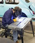 Person welding at Built Rugged Foldable Welding And Fixturing Table Packing 500 Pound Capacity And Industry Standard Holes.