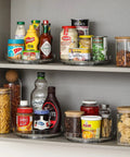 Four Pack 9 Inch Clear Acrylic Lazy Susans Non Skid Turntables Organizer For Cabinets showing pantry items organized.