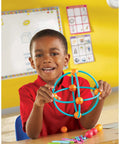 Child using Geometric Shapes Building Set For Kids Ages Five And Up 170 Pieces Kid Friendly Hands On Math Learning Kit to form a sphere.