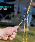 CamJam SlideLock Bungee Cord Tightener With Pull To Tighten Lock And Quick Release Lever used on yellow cord outdoors