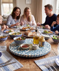 Two Pack Mother Of Pearl Lazy Susan Turntable Set With Blue Wicker 12 And 13 Inch Rotating Trays on dining table.