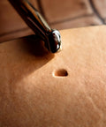 Close-up of leather beveling tool with alloy steel head creating an impression, part of Leather Beveling Tools And Stamp Set With Alloy Steel Precision Heads