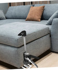 Solid Grip Handheld Leveling Jack Pair in use under a sofa cushion for easy height adjustment and support.