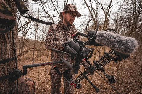 Hunter using Stiff Arm Tree Camera Arm Mount, Lightweight Aluminum With 360 Tool-Less Leveling for stable outdoor filming.