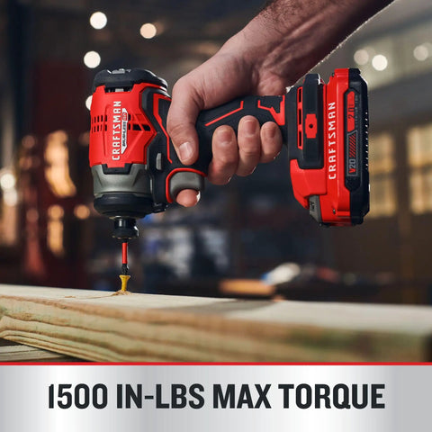Hand holding brushless cordless impact driver with one quarter inch chuck demonstrating 1500 in lbs torque on wood surface.
