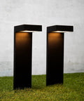Set Of 2 Modern Solar Black Outdoor L-Shaped Path Lights With Bright LED on grass, solid metal aluminum stake, illuminated
