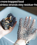 Hands holding cast iron scrubber with stainless steel chainmail next to a soiled sponge in a kitchen sink, showcasing its residue-free properties.