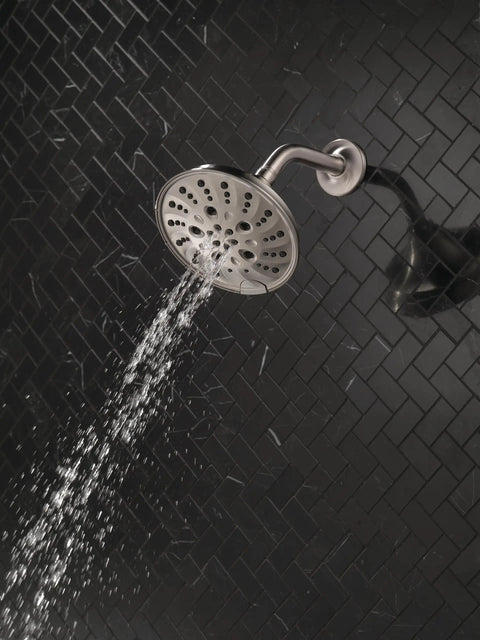H2Okinetic Rain Shower Head With Five Settings In Stainless Finish Touch Clean Nozzle System in use on black tile wall