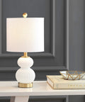 Ribbed Gourd Glass Table Lamp In White And Brass Gold Dope Modern Bedside Light With White Linen Drum Shade 20 Inch Tall LED Bulb Included Perfect For Bedroom Or Living Room on a white console table next to decor items.