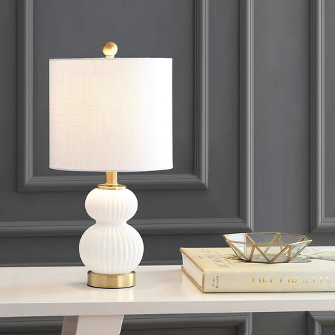 Ribbed Gourd Glass Table Lamp In White And Brass Gold Dope Modern Bedside Light With White Linen Drum Shade 20 Inch Tall LED Bulb Included Perfect For Bedroom Or Living Room on a white console table next to decor items.