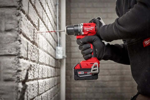 Person using M18 Compact Brushless Hammer Drill Driver With Half Inch Metal Chuck And All Metal Gear Case for brick wall drilling.